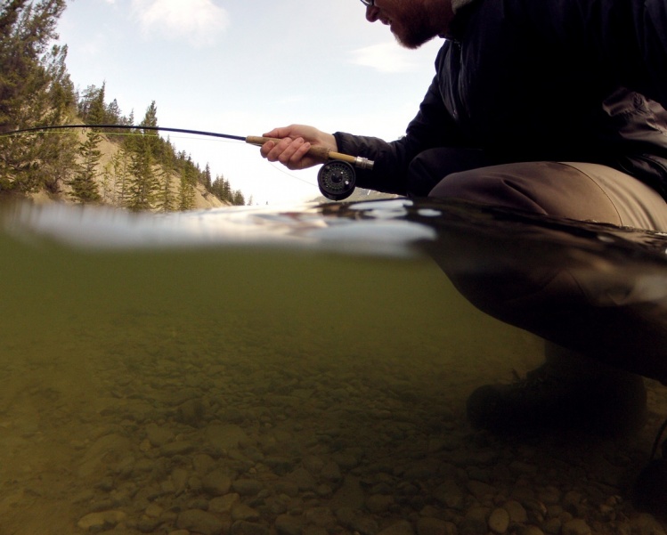 getting your lens halfway under water makes an interesting POV (point of view). it kinda give the viewer an idea of what the water your fishing feels like. i like it anyway.