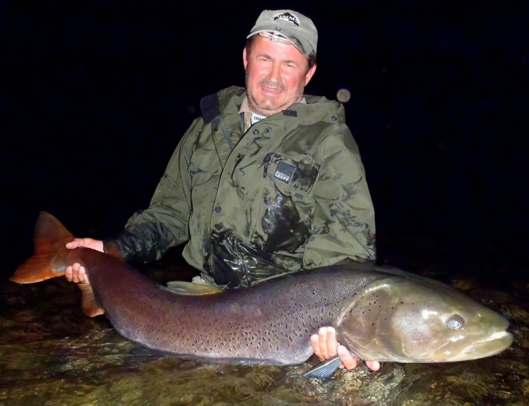 Happy fisherman with a well-earned trophy Hucho Taimen