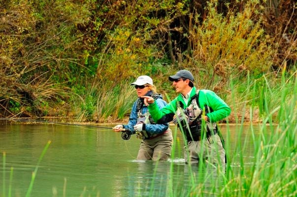 Guide, Ivan Taren, and Cathy study a fish.