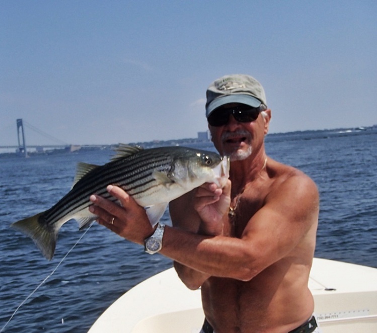 My friendCharlie with a nice summertime striper, shirts off and bluebird skies really not striper weather but we'll take it.