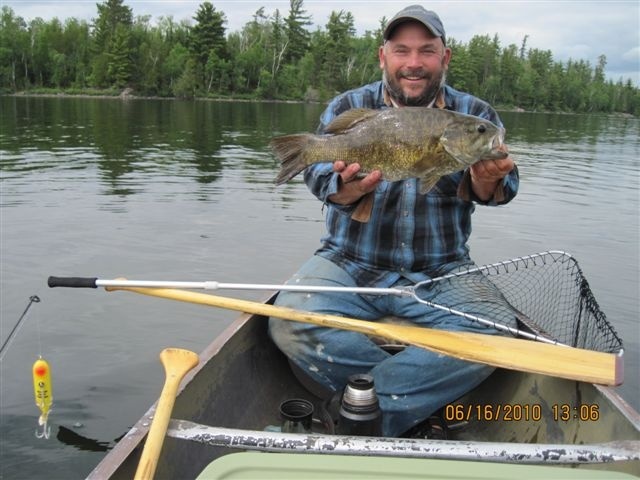 The fellow in the bow caught this smallmouth bass on top with his flyrod. Really! (That tiny torpedo was the client's located in the middle seat of my big 19 foot square stern guide canoe)